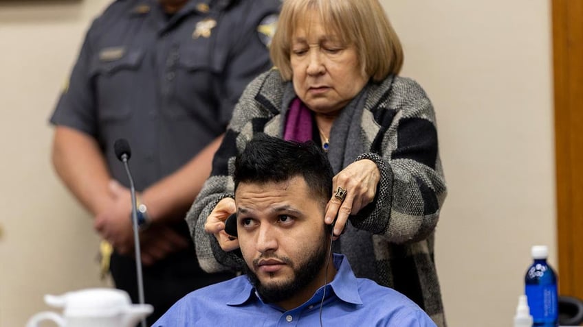 A translator assists defendant Jose Ibarra with his headphones during his trial at the Athens-Clarke County Superior Court, Tuesday, Nov. 19, 2024, in Athens, Ga. 