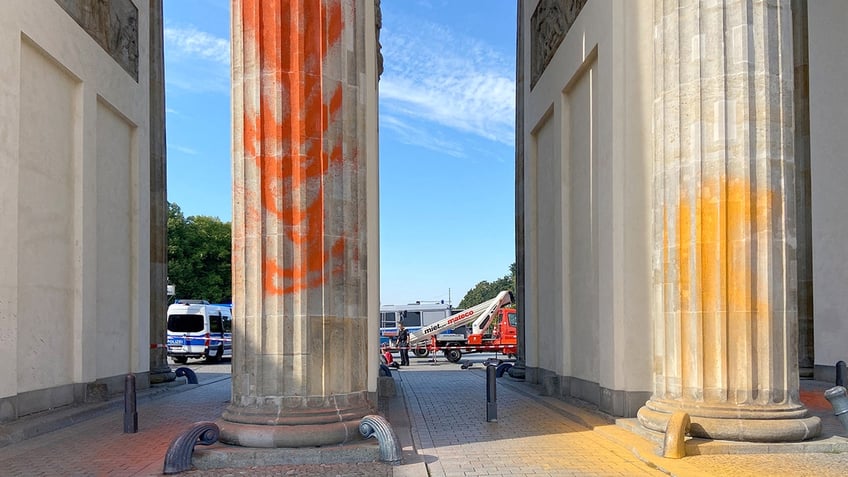 german climate protestors spray paint brandenburg gate columns