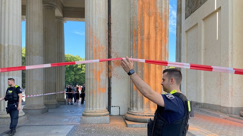 german climate protestors spray paint brandenburg gate columns