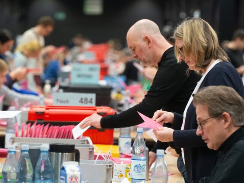 A general view shows volunteers counting the postal votes at the Cologne Trade Fair Center