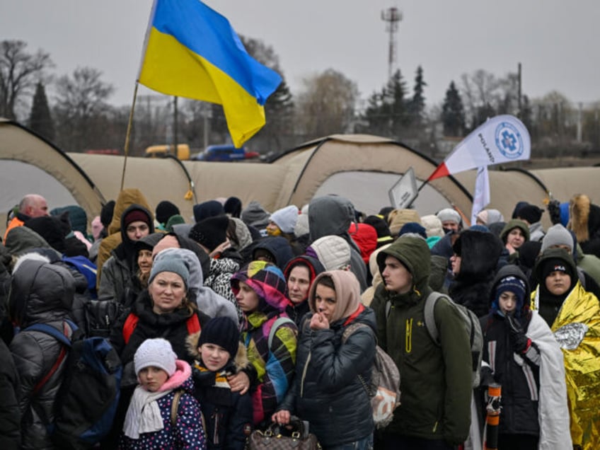 Hundreds of refugees stand in line as they wait to be transferred after crossing the Ukrai