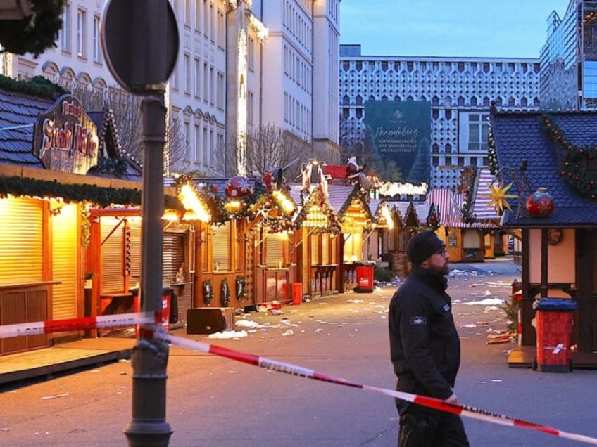 MAGDEBURG, GERMANY - DECEMBER 21: A policeman walks through the shuttered Christmas market