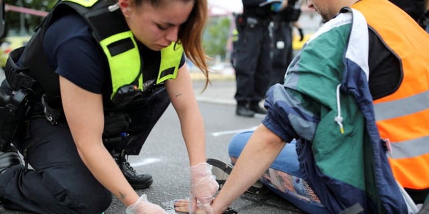 german woman drags radical climate activist by hair for blocking traffic as publics anger mounts