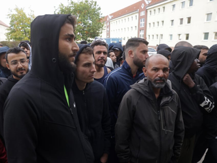 EISENHUETTENSTADT, GERMANY - OCTOBER 05: Men, most of them from Syria, queue for lunch at
