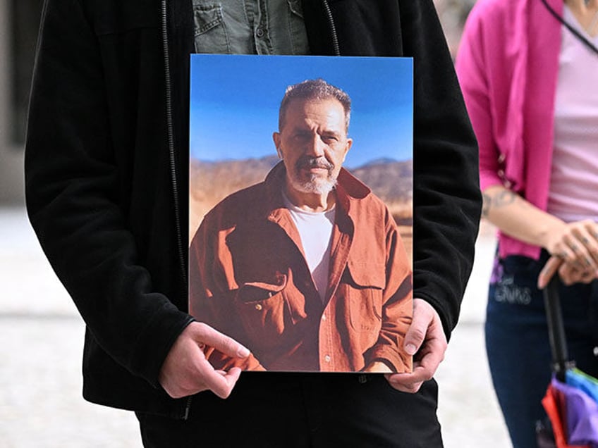 A demonstrator holds a picture of Iranian-German Jamshid Sharmahd, who has been sentenced