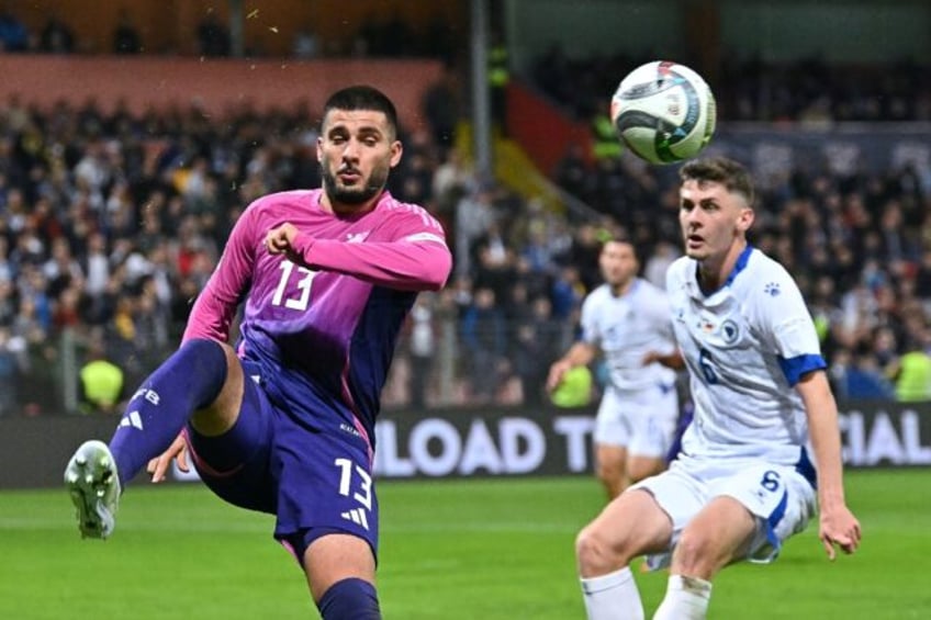 Double top: Germany forward Deniz Undav (L) fights for the ball with Bosnia and Herzegovin