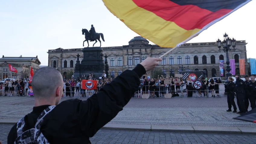 DRESDEN, GERMANY - AUGUST 29: A skinhead supporter of the far-right Alternative for Germany (AfD) political party waves a German flag while taunting leftist, anti-fascist protesters following the final AfD Saxony election rally prior to state elections on August 29, 2024, in Dresden, Germany. The AfD is currently leading in polls in both Saxony and Thuringia ahead of state elections scheduled for Sunday in both states. (Photo by Sean Gallup/Getty Images)