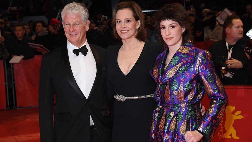 Sigourney Weaver posing with her husband and child