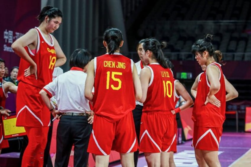The 2.20m (7ft 3in) Zhang Ziyu, left, is towering over her opponents and teammates at this