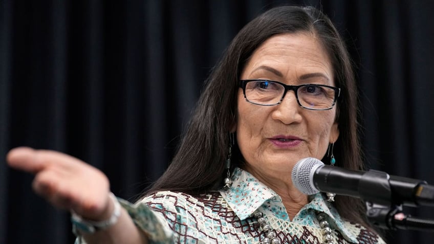 Interior Secretary Deb Haaland speaks behind microphone at event