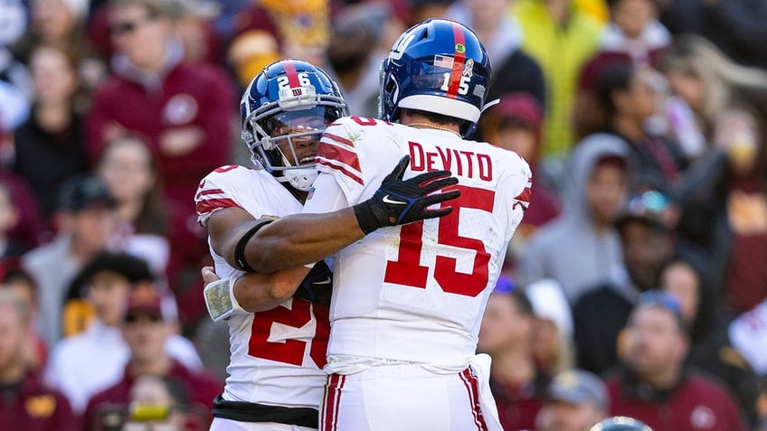 Tommy DeVito hugs Saquon Barkley