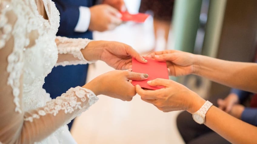 Newlyweds receives money in red envelopes.