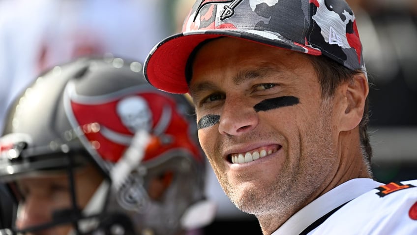 Tom Brady smiles in his camouflage Bucaneer's hat