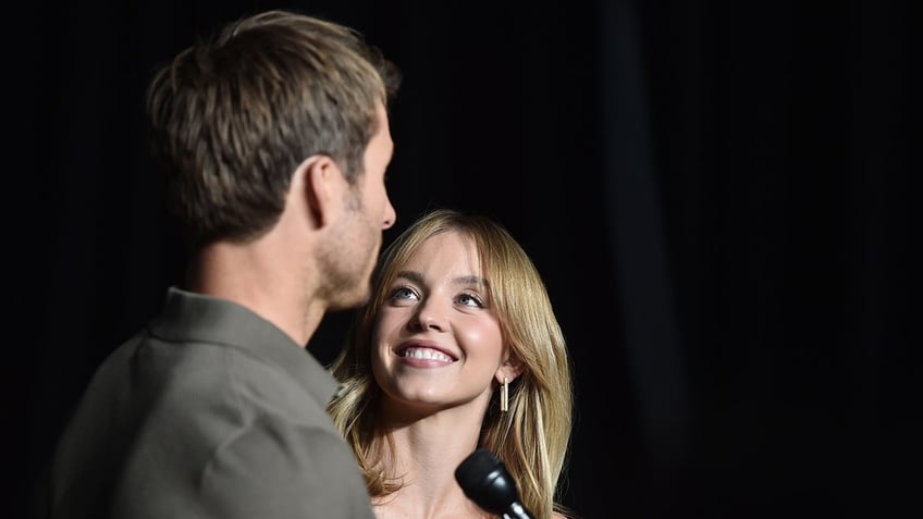 Sydney Sweeney looks up longingly at co-star Glen Powell