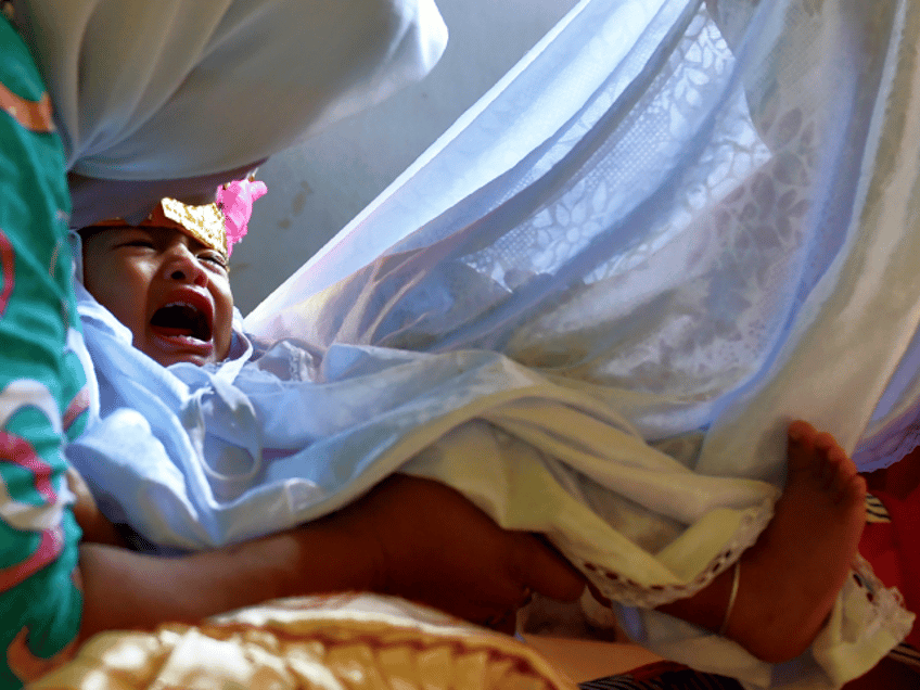 In this photograph taken on February 20, 2017, toddler Salsa Djafar cries as a traditional healer conducts a circumcision, in Gorontalo in Indonesia's Gorontalo province. Female circumcision -- also known as female genital mutilation or FGM -- has been practised for generations across Indonesia, which is the world's biggest Muslim-majority country, and is considered a rite of passage by many. / AFP PHOTO / BAY ISMOYO / TO GO WITH Indonesia-religion-rights-women,FEATURE by Olivia Rondonuwu (Photo credit should read BAY ISMOYO/AFP/Getty Images)