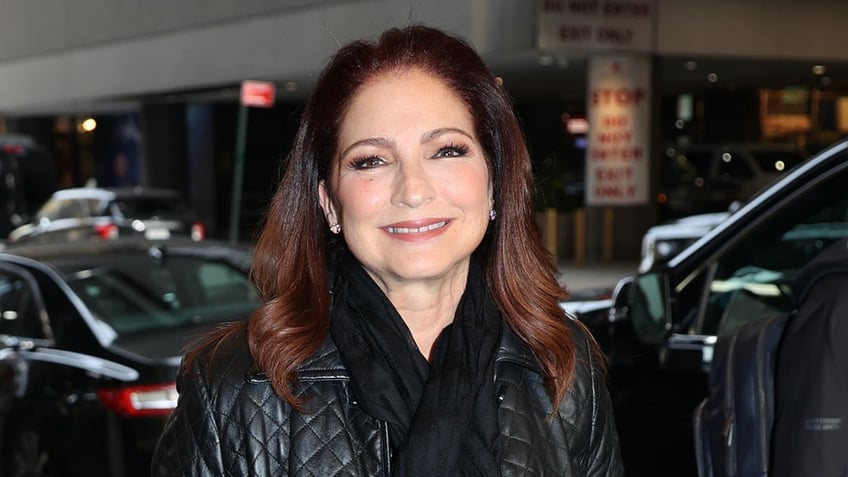 Gloria Estefan wears leather coat and scarf in New York City.