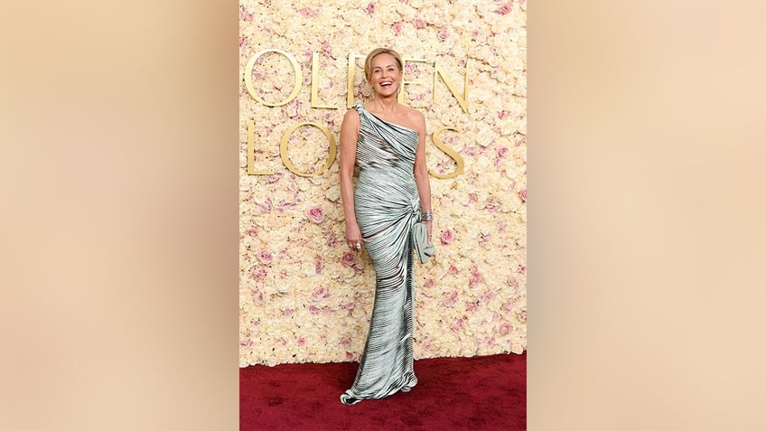 Sharon Stone wore a one-shoulder blue gown with black mixed in and a knot tied on the side to the 2025 Golden Globe Awards.