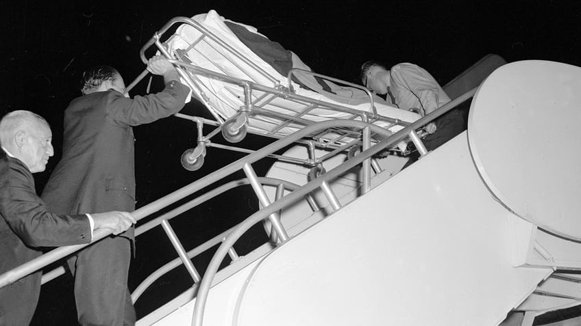 Vivien Leigh being held up in a stretcher.