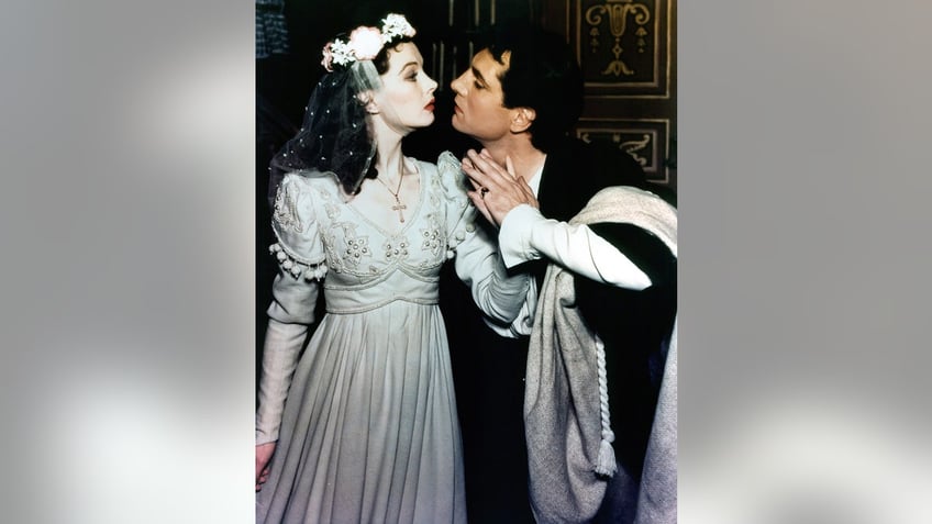 Laurence Olivier leaning for a kiss from Vivien Leigh as they're both in Shakespearean costumes.