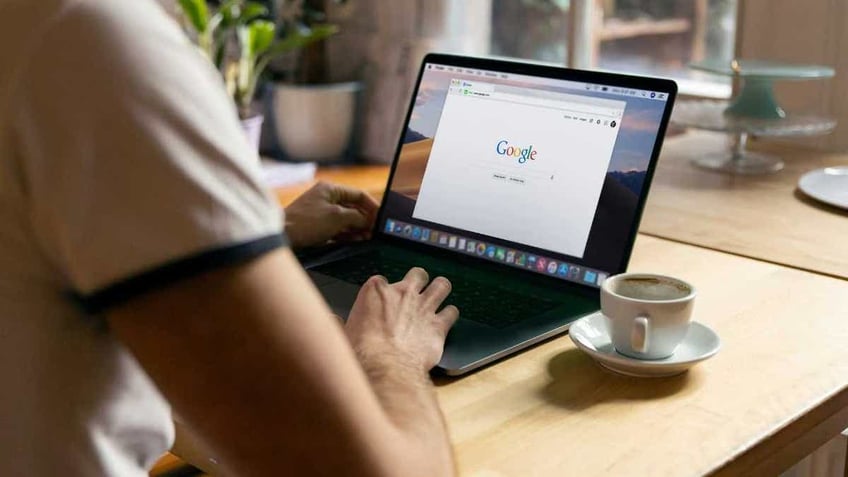 A person browses Google on a laptop.