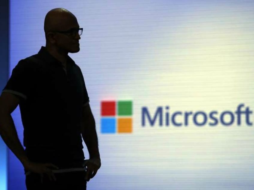 FILE- In this May 7, 2018, file photo Microsoft CEO Satya Nadella looks on during a video as he delivers the keynote address at Build, the company's annual conference for software developers in Seattle. Microsoft is threatening to overtake Apple as the world’s most valuable publicly traded company. The market closed Tuesday, Nov. 27, with Microsoft just behind Apple. (AP Photo/Elaine Thompson, File)