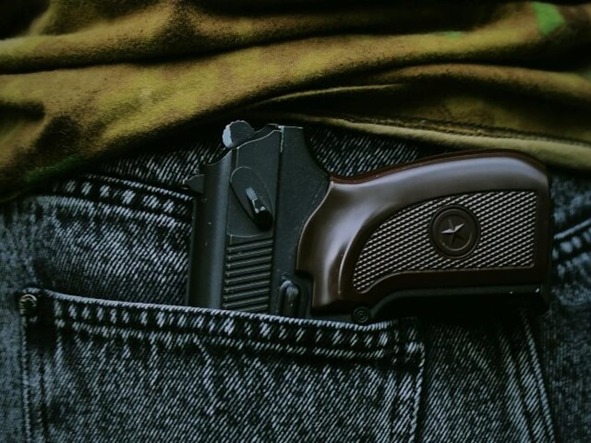 close up of gun in jeans pocket