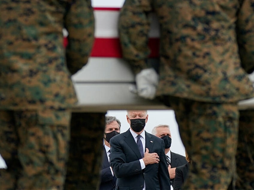 FILE - President Joe Biden watches as a carry team moves a transfer case containing the re