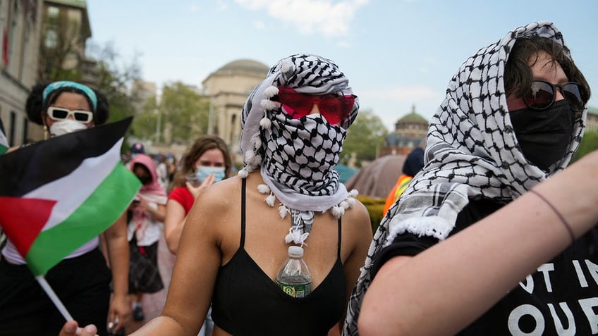 A protester holds a Palestinian flag during a march on Columbia University campus