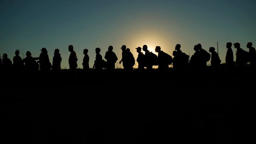 migrants at Eagle Pass, Texas border crossing lined up for processing