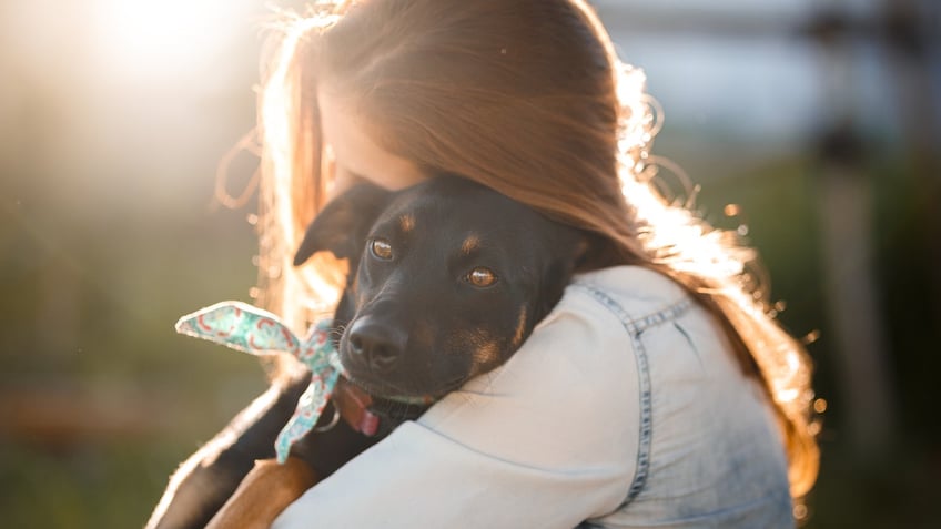 girl hugging dog