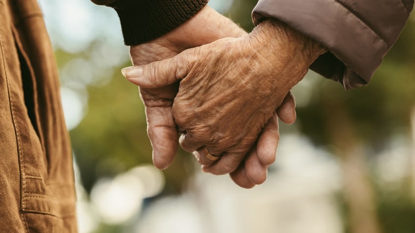 Old couple holding hands