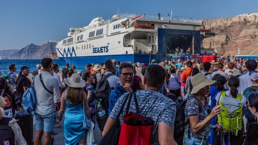 ourists from all over the world arrive or depart from the port of Thira