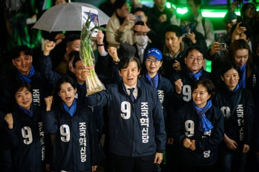 Cho Kuk, leader of the Rebuilding Korea Party, holds up green onions at a campaign event i