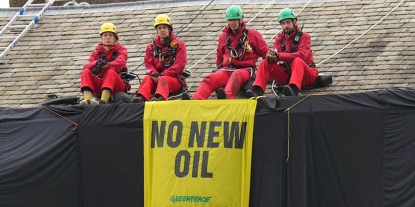 greenpeace climate protesters climb atop uk prime ministers home hang black fabric