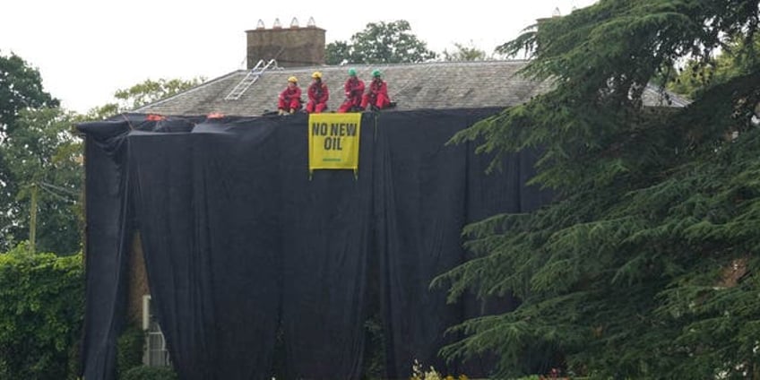 greenpeace climate protesters climb atop uk prime ministers home hang black fabric