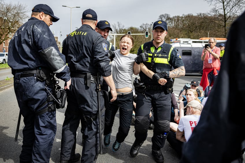 Swedish climate activist Greta Thunberg (C) is arrested during a climate march against fossil subsidies near the highway A12 in the Hague, on April 6, 2024. Dozens of police officers, some on horseback, blocked protesters from reaching the A12 arterial highway into the Dutch seaside city, the scene of previous actions organised by the Extinction Rebellion (XR) group (Photo by Ramon van Flymen / ANP / AFP) / Netherlands OUT (Photo by RAMON VAN FLYMEN/ANP/AFP via Getty Images)