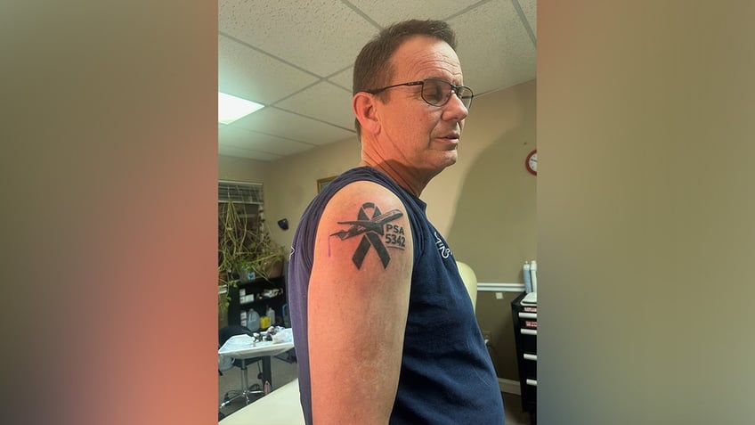 Timothy Lilley shows the tattoo he received to honor his son, Sam Lilley