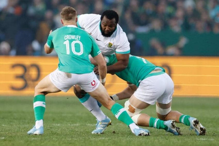 South Africa prop Ox Nche (C) is tackled by Ireland fly-half Jack Crowley (L) and flanker