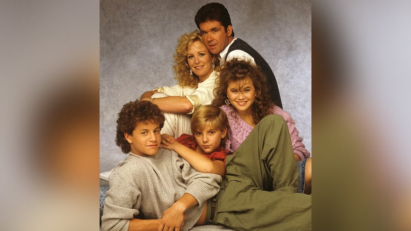 "Growing Pains" cast Alan Thicke holds onto TV wife Joanna Kerns with their three children Mike (Kirk Cameron), Carol (Tracey Gold) and Ben (Jeremey Miller) in front of them