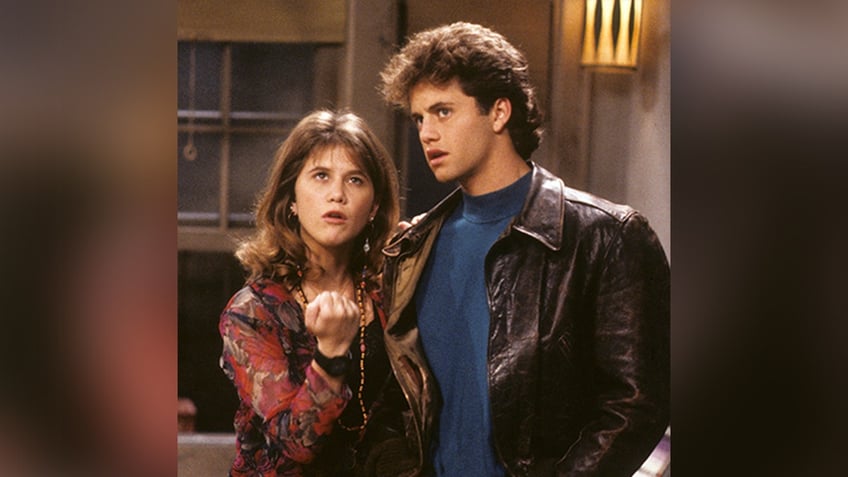 Tracey Gold and Kirk Cameron as Carol and Mike Seaver both looking up in conversation during an episode of "Growing Pains"