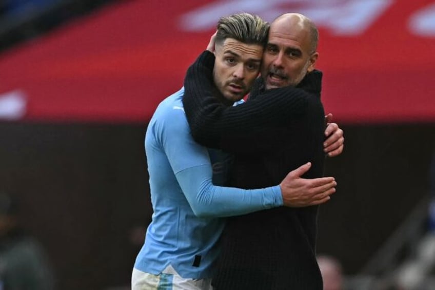 Manchester City manager Pep Guardiola embraces Jack Grealish