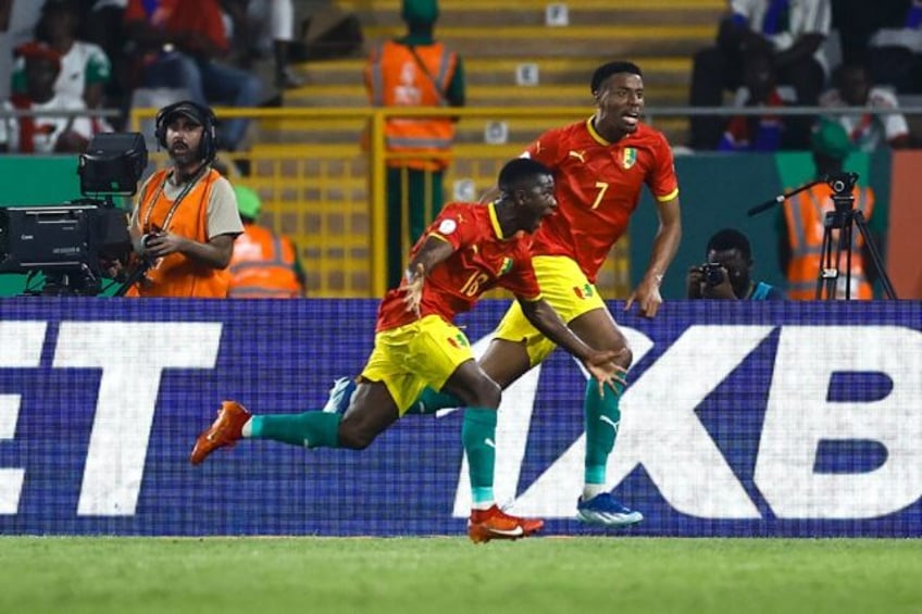 Aguibou Camara (L) celebrates scoring Guinea's winning goal against Gambia