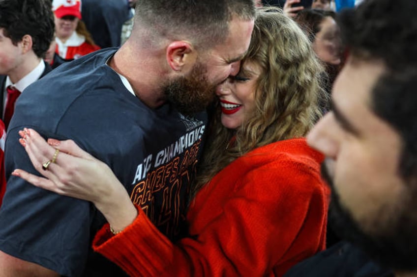 Travis Kelce of the Kansas City Chiefs celebrates with Taylor Swift after defeating the Baltimore Ravens in the AFC Championship Game at M&T Bank...