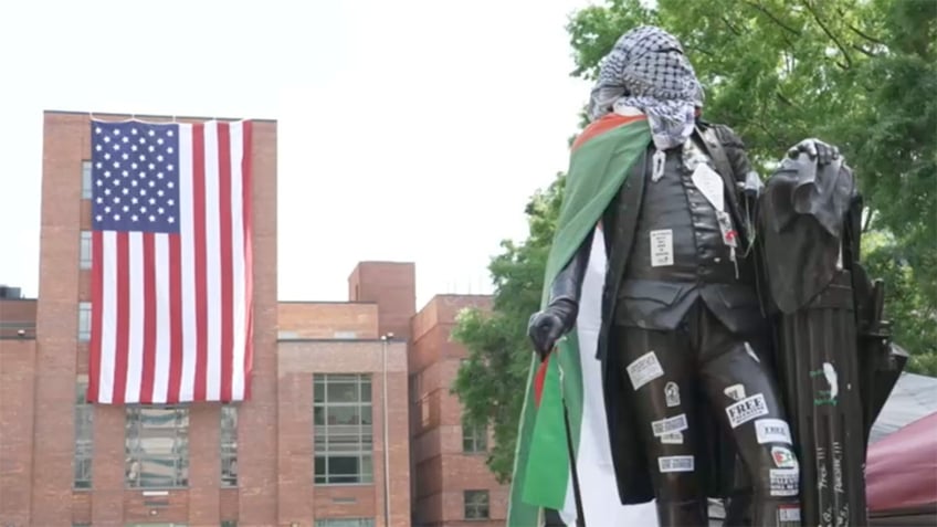 A large American flag is unfurled at George Washington University