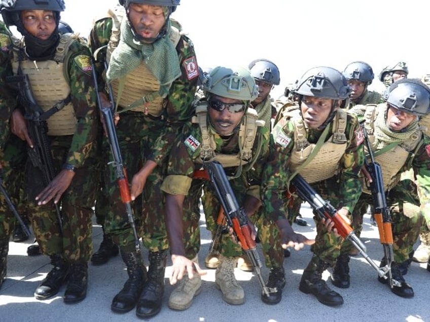 Kenyan police, who are part of a UN-backed multinational force, sing and dance on the tarm