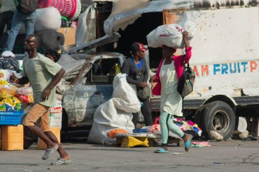 People run after hearing gunshots in Port-au-Price, Haiti, on April 13, 2024