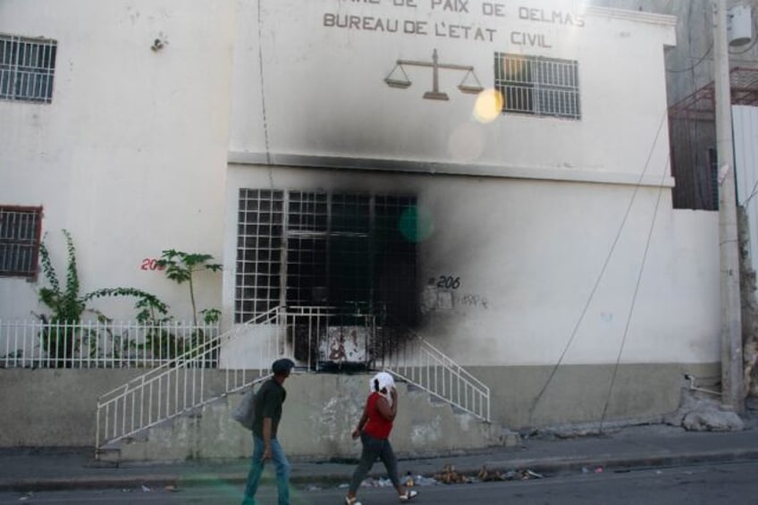 Residents walk near a Port-au-Prince courthouse attacked by gangs on March 6, 2024