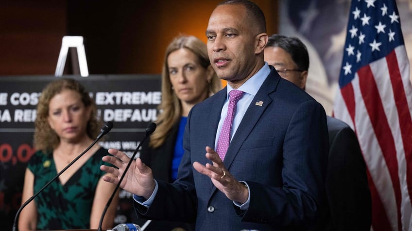 US House Minority Leader Hakeem Jeffries speaks at a podium with other members of House Democratic leadership standing beside him