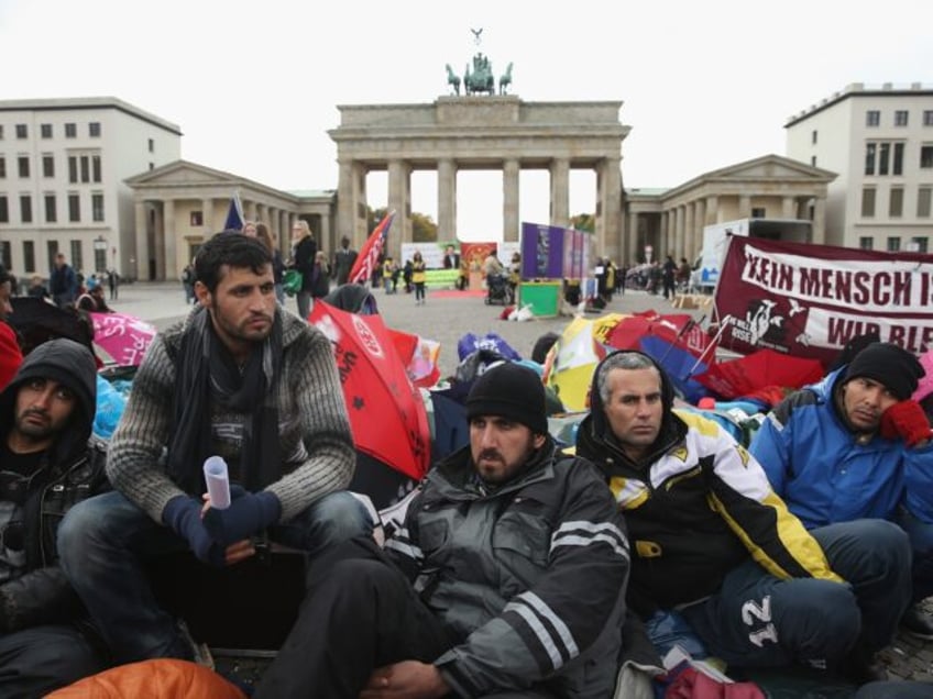 BERLIN, GERMANY - OCTOBER 17: Refugees from Iraq, Iran and Afghanistan keep warm on the 8t