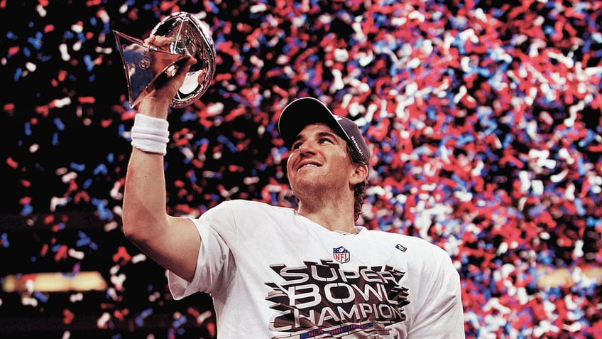 Eli Manning hoisting trophy